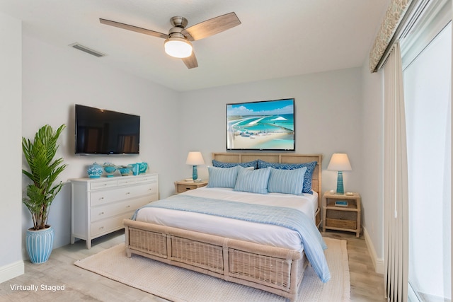 bedroom featuring light wood-style floors, visible vents, ceiling fan, and baseboards