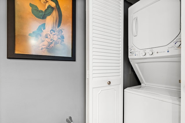 washroom featuring stacked washer / drying machine