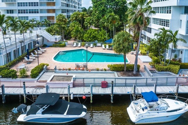 view of pool featuring a water view and a patio area