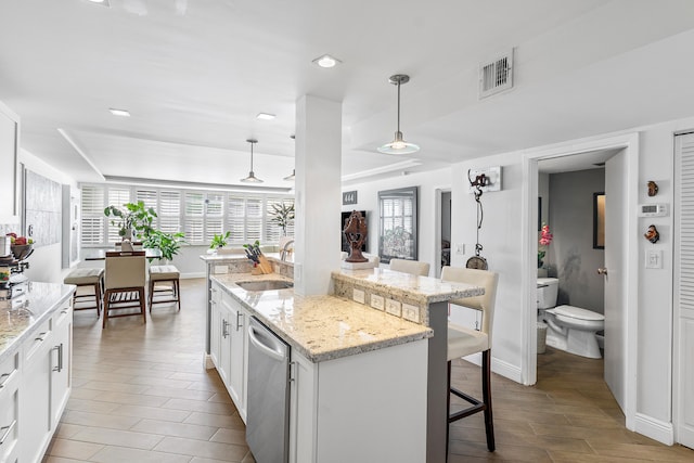 kitchen featuring white cabinets, decorative light fixtures, and a wealth of natural light