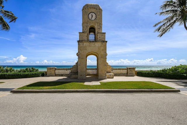 surrounding community with a water view and a yard