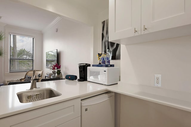 kitchen with white cabinets, white appliances, sink, and crown molding