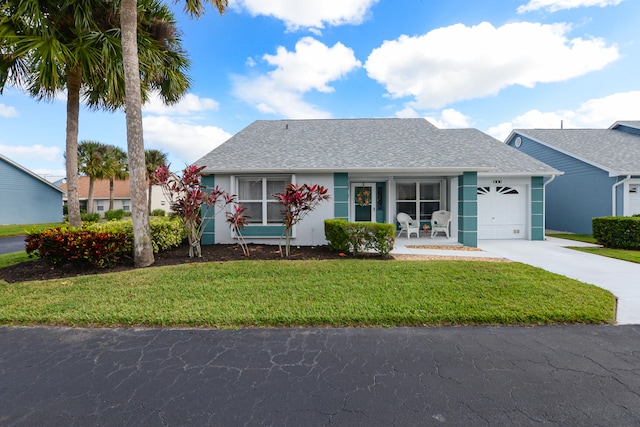 view of front of home featuring a front lawn, covered porch, and a garage