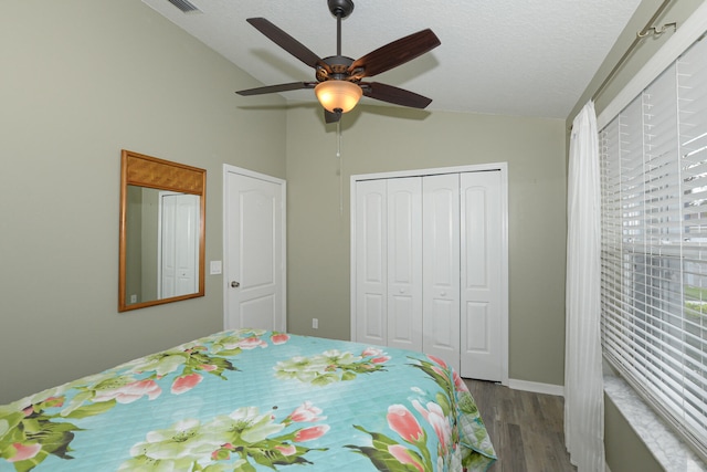 bedroom featuring lofted ceiling, ceiling fan, a textured ceiling, light hardwood / wood-style floors, and a closet