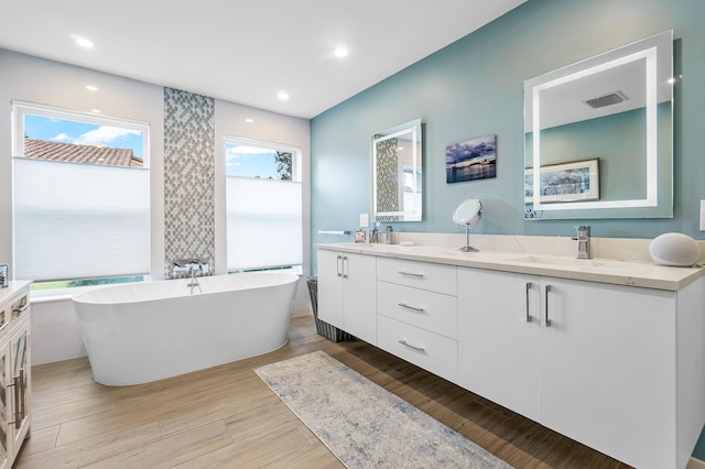 bathroom featuring vanity, a tub to relax in, and hardwood / wood-style floors