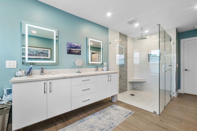 bathroom with vanity, an enclosed shower, and hardwood / wood-style floors