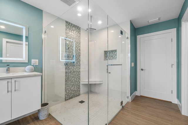 bathroom with a shower with door, vanity, and hardwood / wood-style flooring