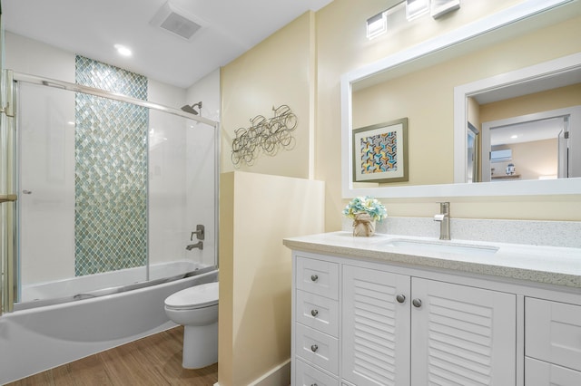 full bathroom with vanity, toilet, enclosed tub / shower combo, and hardwood / wood-style floors