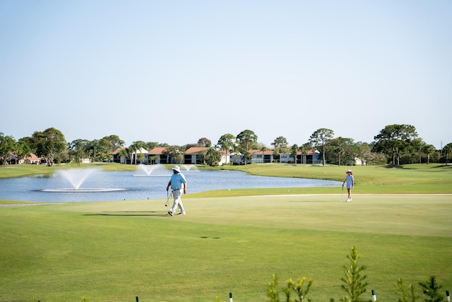 view of property's community with a water view and a yard