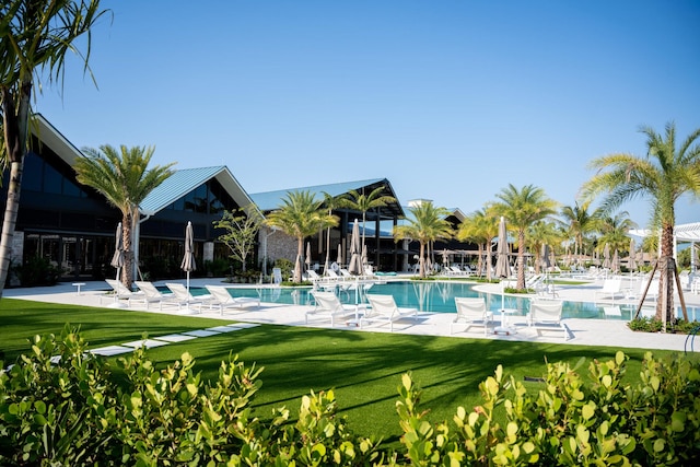 view of swimming pool featuring a patio area and a yard