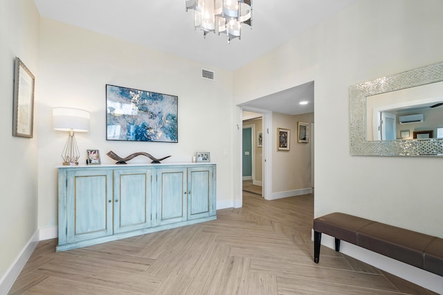 corridor featuring a notable chandelier, light parquet flooring, and a wall unit AC