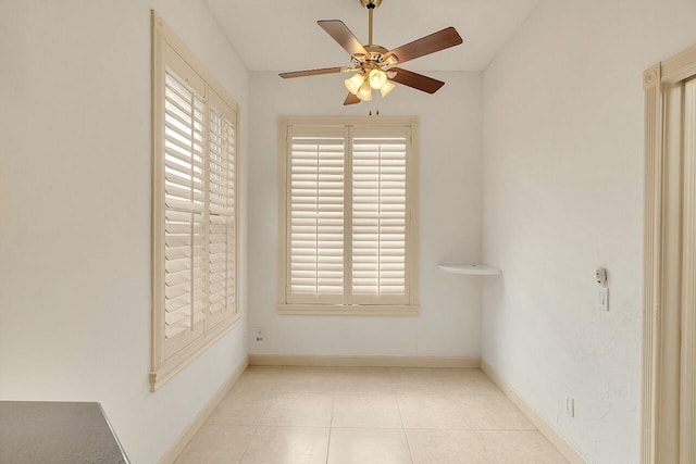 tiled spare room featuring ceiling fan