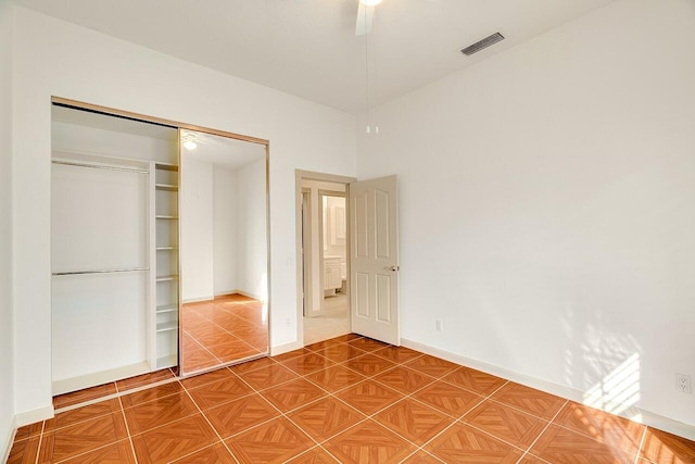 unfurnished bedroom with ceiling fan and a closet