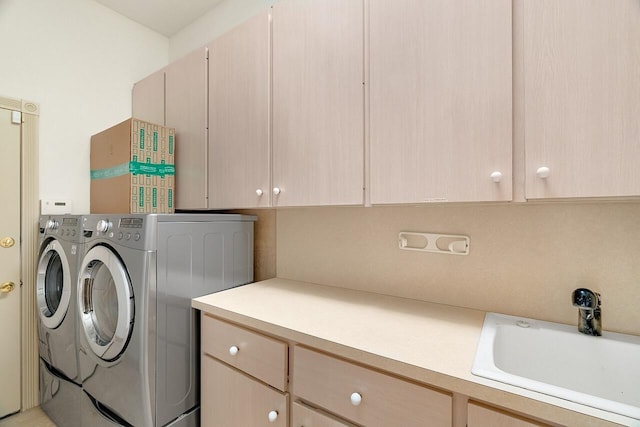 laundry area featuring cabinets, washer and clothes dryer, and sink