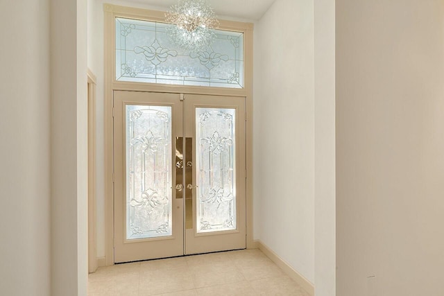 entryway featuring french doors, a notable chandelier, and light tile patterned flooring