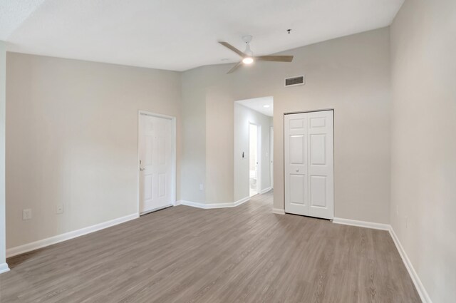 spare room with light hardwood / wood-style flooring, high vaulted ceiling, and ceiling fan