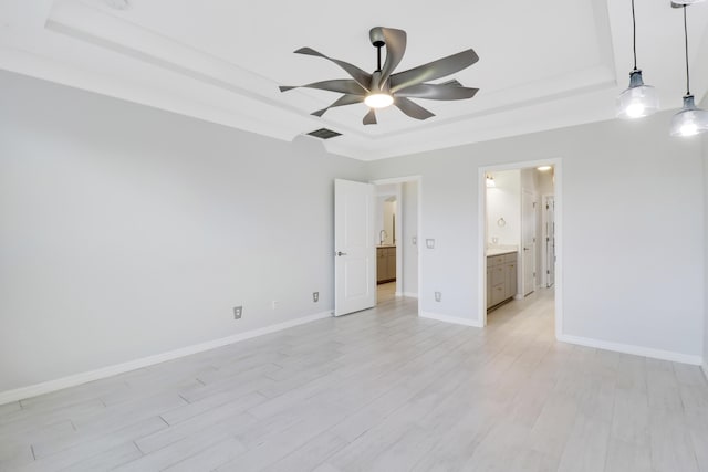 unfurnished room featuring light hardwood / wood-style flooring, a raised ceiling, and ceiling fan