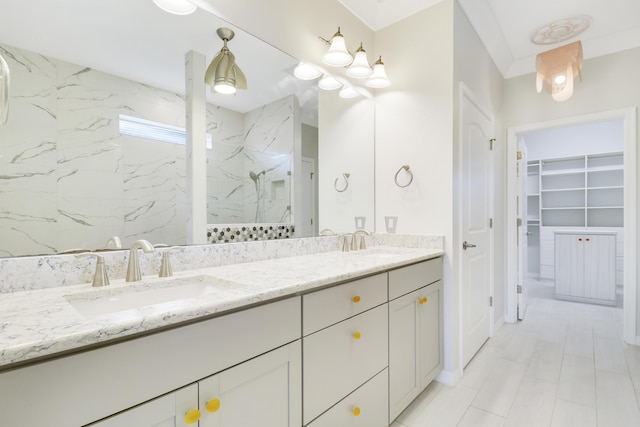 bathroom with a tile shower and vanity