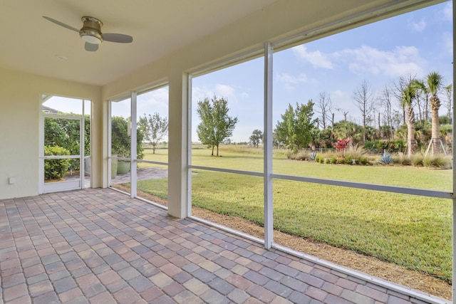 unfurnished sunroom with ceiling fan