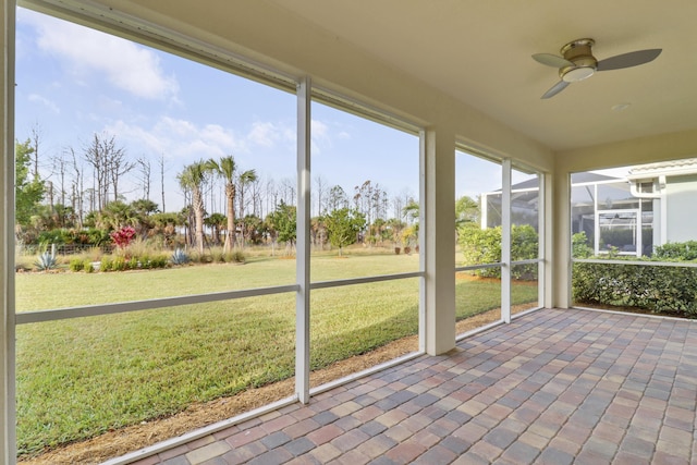 unfurnished sunroom with ceiling fan