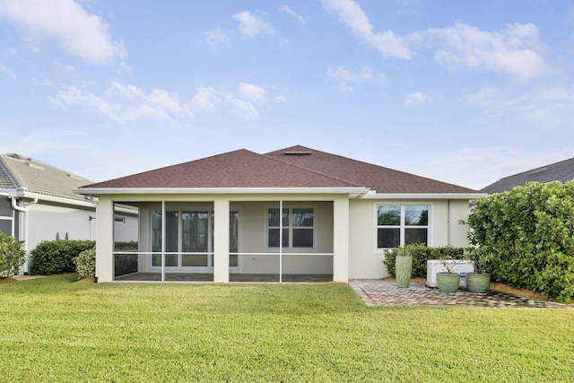 back of house featuring a sunroom and a lawn