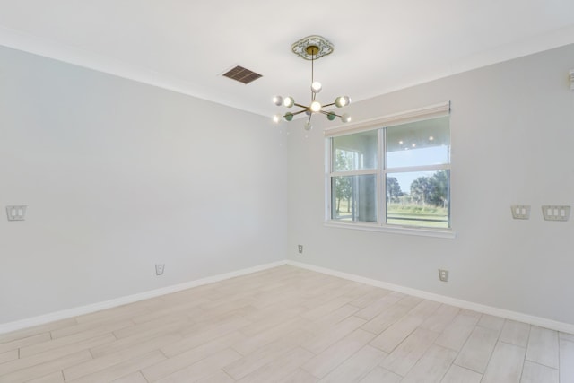 empty room featuring crown molding and a chandelier