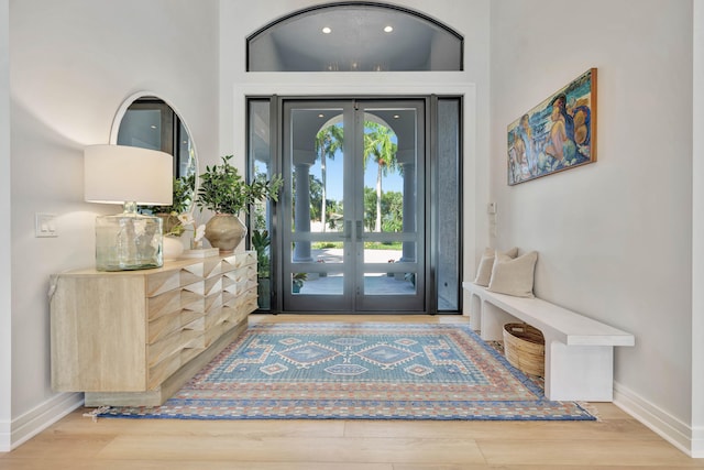 foyer featuring french doors, hardwood / wood-style flooring, and a high ceiling