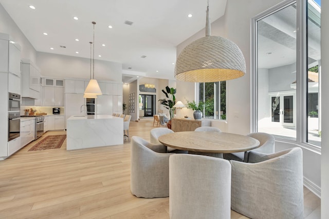 dining space with sink and light hardwood / wood-style floors