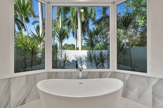 bathroom featuring tile walls and a bath