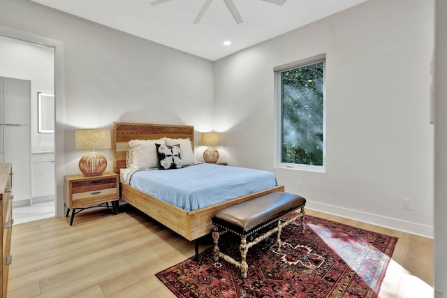 bedroom featuring light hardwood / wood-style flooring, ensuite bathroom, and ceiling fan