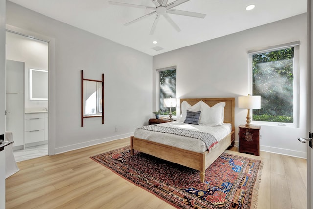 bedroom featuring light hardwood / wood-style flooring, ensuite bath, and ceiling fan