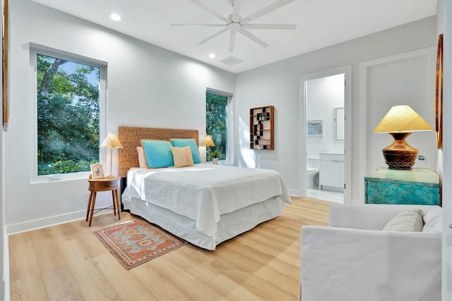 bedroom with connected bathroom, hardwood / wood-style flooring, and ceiling fan