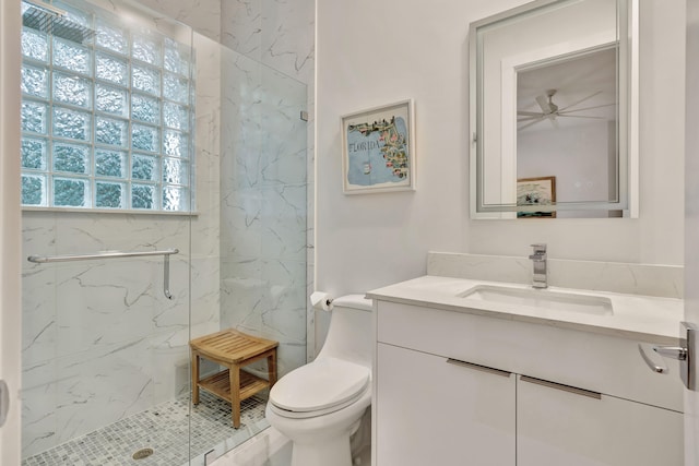 bathroom featuring vanity, toilet, plenty of natural light, and a shower with door