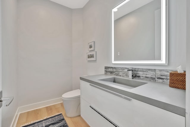 bathroom featuring toilet, vanity, and wood-type flooring