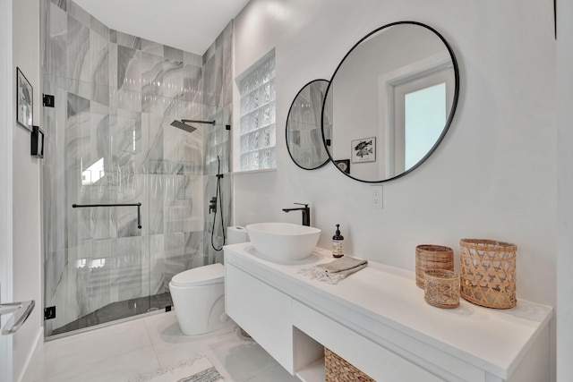 bathroom featuring a shower with door, vanity, toilet, and tile patterned flooring