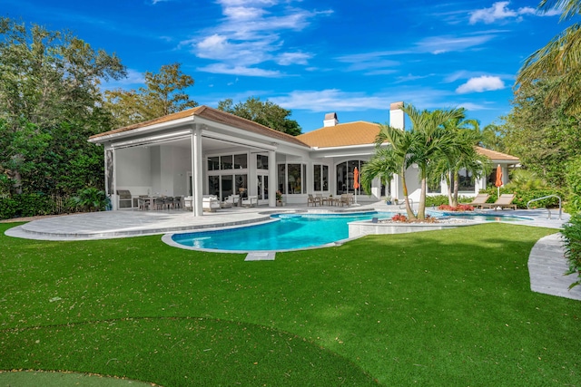 rear view of house with a patio and a yard