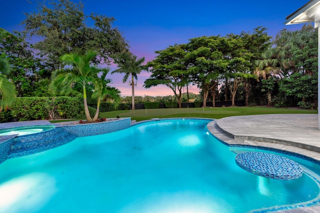 pool at dusk featuring a lawn