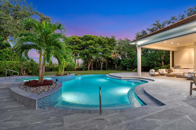 pool at dusk with a patio and outdoor lounge area