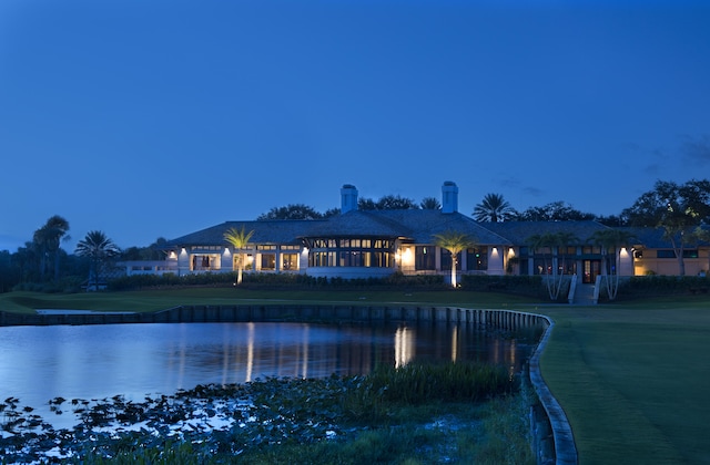 back house at dusk with a water view