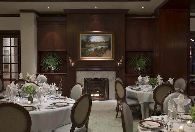 dining space featuring a premium fireplace, carpet floors, and ornamental molding