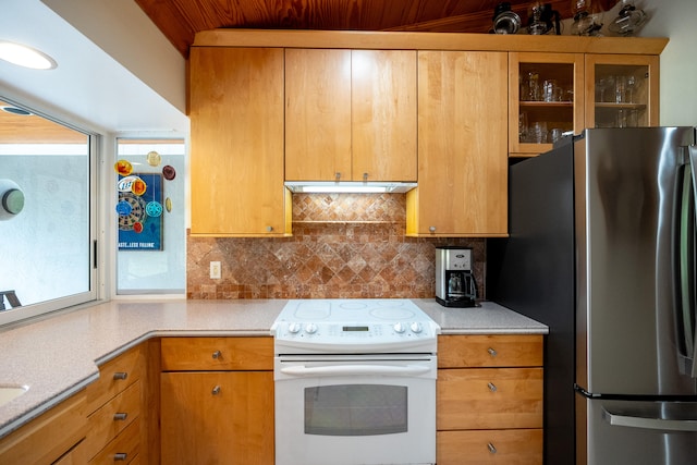 kitchen featuring white range with electric stovetop, tasteful backsplash, and stainless steel refrigerator