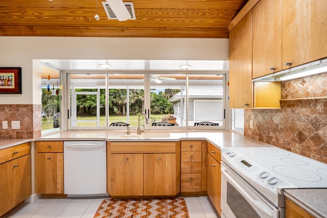 kitchen featuring sink, decorative backsplash, white appliances, and light tile patterned floors