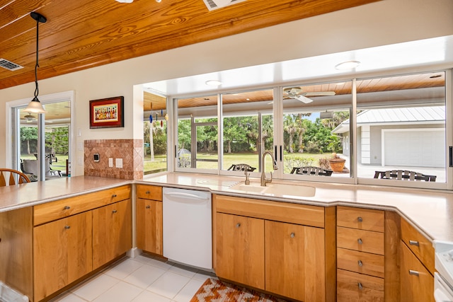 kitchen with kitchen peninsula, light tile patterned floors, dishwasher, pendant lighting, and sink