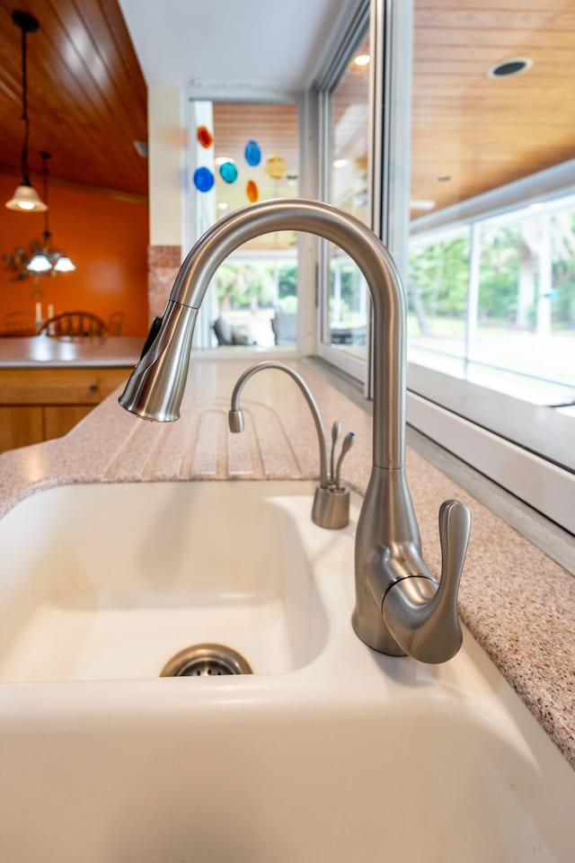 room details featuring sink, wood ceiling, and decorative light fixtures