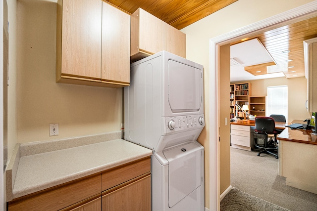 washroom with cabinets, carpet floors, stacked washer and dryer, and wooden ceiling