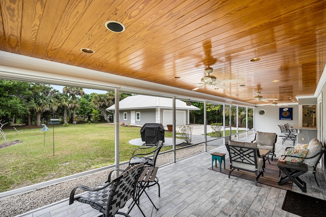 sunroom / solarium with wood ceiling, plenty of natural light, and ceiling fan