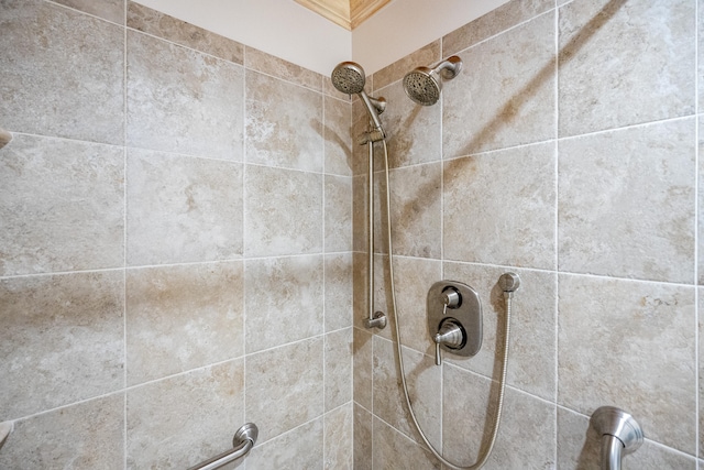 interior details featuring a tile shower and ornamental molding