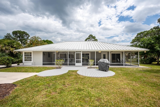 back of house featuring a yard and a sunroom