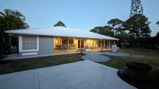 rear view of property with a patio and a yard