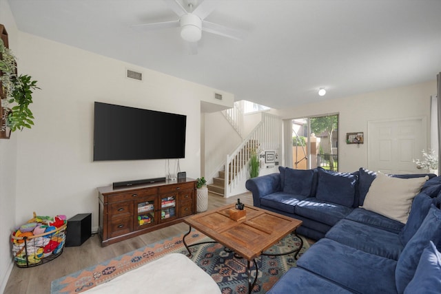 living room with light hardwood / wood-style flooring and ceiling fan